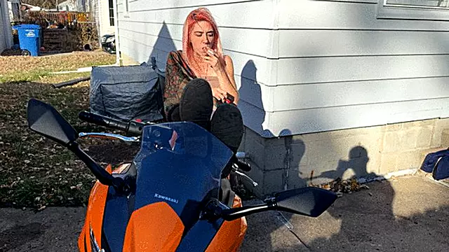 Alice smokes a cigarette while posing on her motorcycle (4k)