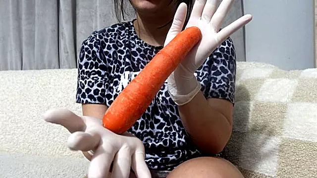 My Stepsister in medical white gloves plays with a yellow carrot