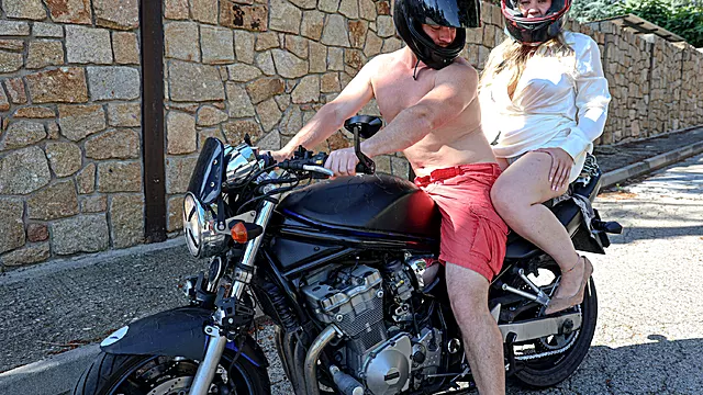 Busty blonde screws a biker on his motorcycle while outside