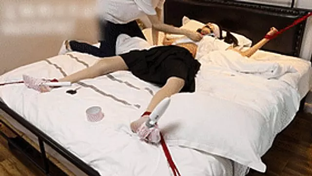 GG38 - Cute Asian girl in short skirt and stockings is bound to the bed and tickled.