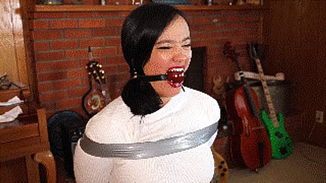 Raven Lynette tied during an undercover mission, first gagged with ballgag then mouth heavily stuffed and wraparound gagged with clear tape