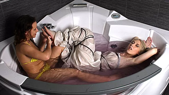 Alexa and Bianca: barefoot blonde girl, wrapped in cloth and bound with rope, is being tickled and teased by roommate in jacuzzi (HD MOV)